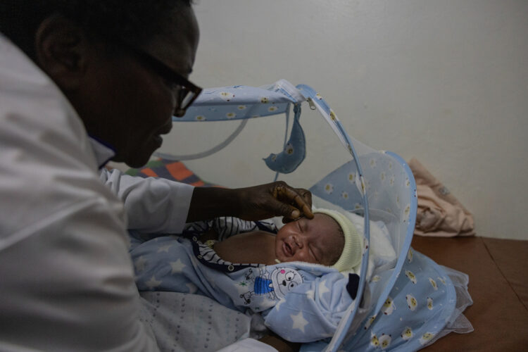 Jane Mpanga, a midwife checks on a new born baby at her clinic in Kireka, Kampala.